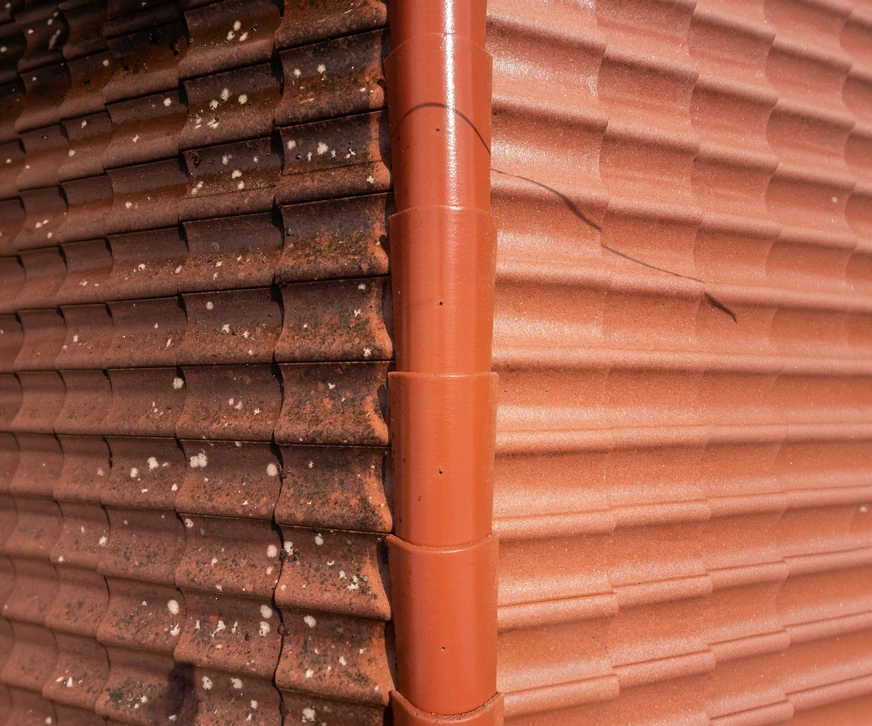 Comparer le toit de tuiles propres avant et après le nettoyage du lessive de mousse de qualité de l'eau