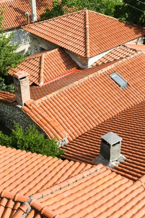 Couvreur zingueur sur un toit en travail de zinguerie, portant casque de s&eacute;curit&eacute; jaune et &eacute;quipement professionnel, en train de mettre en place ou travailler des &eacute;l&eacute;ments de zinguerie (goutti&egrave;res, descentes, trait&eacute;s en zinc ou mat&eacute;riaux similaires) sur une structure de b&acirc;timent. Sc&egrave;ne professionnelle et s&eacute;curis&eacute;e, en conditions r&eacute;elles de chantier.